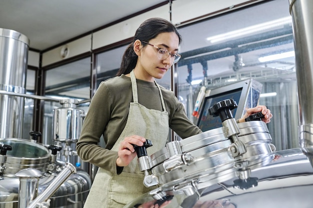 Vrouwelijke jonge ingenieur die aan apparatuur werkt