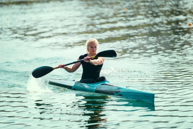 Vrouwelijke kayaker die op meer traint