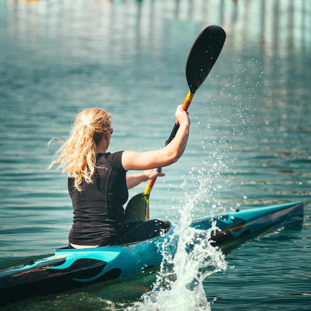 Vrouwelijke kayaker die op meer traint