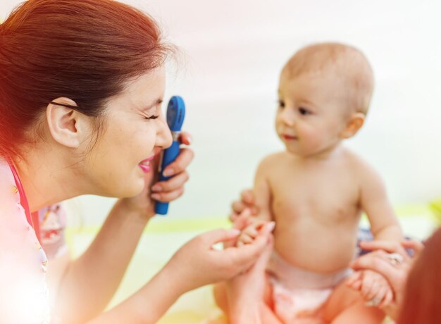 Vrouwelijke kinderarts onderzoekt kleine baby in kliniek diagnose van het gezichtsvermogen van de baby