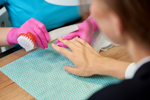 Vrouwelijke klant die professionele manicure in schoonheidssalon ontvangt.