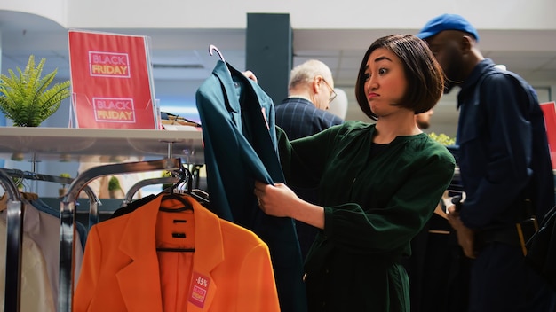 Foto vrouwelijke klant kijkt door kleren.