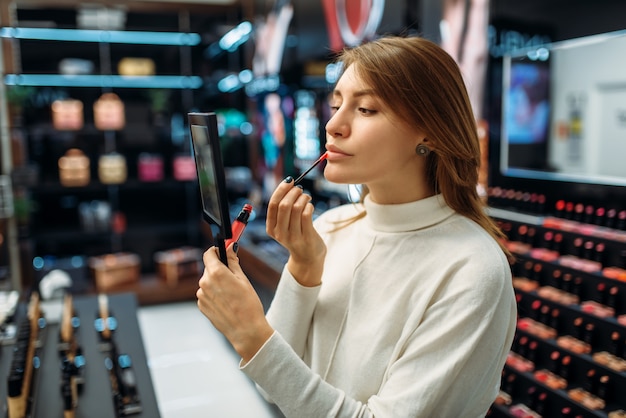 Vrouwelijke klant lip liner testen in make-up winkel
