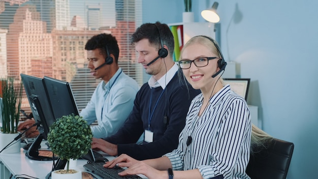 Vrouwelijke klantenservice werken in drukke callcenter.