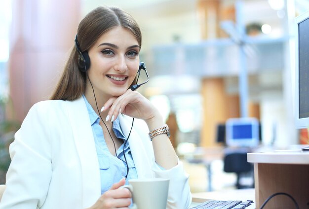 Vrouwelijke klantenservicemedewerker met headset en glimlachen