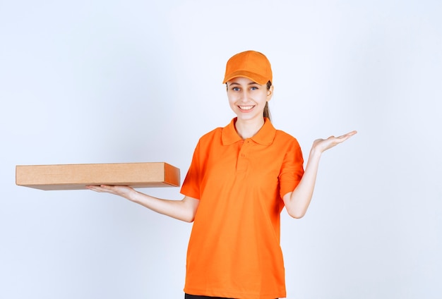 Vrouwelijke koerier in oranje uniform met een afhaalpizzadoos