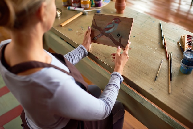 Foto vrouwelijke kunstenaar holding schilderij