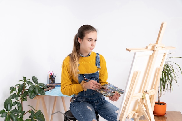 Vrouwelijke kunstenaar schilderen in workshop witte achtergrond
