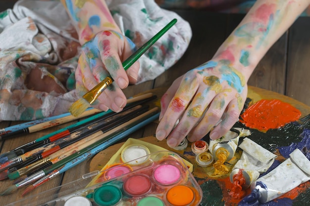 Vrouwelijke kunstenaarshanden met verfborstels