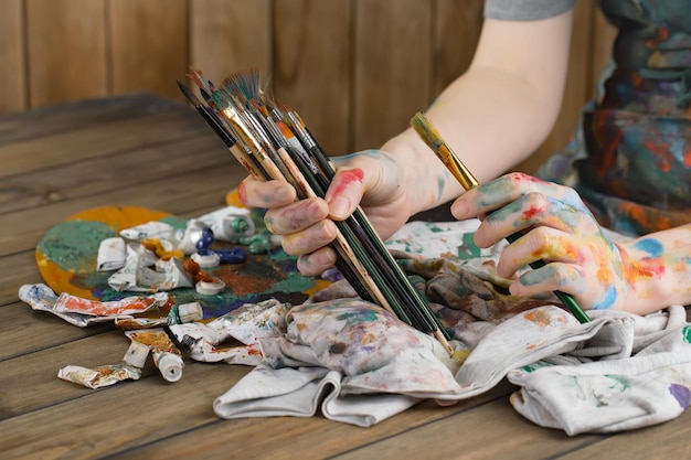 Vrouwelijke kunstenaarshanden met verfborstels
