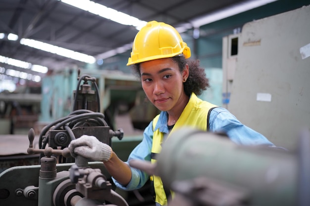 Vrouwelijke leerling in metaalbewerkingsfabriek, portret van werkende vrouwelijke industrie technische arbeider of ingenieur vrouw die werkt in een industrieel fabrieksbedrijf.