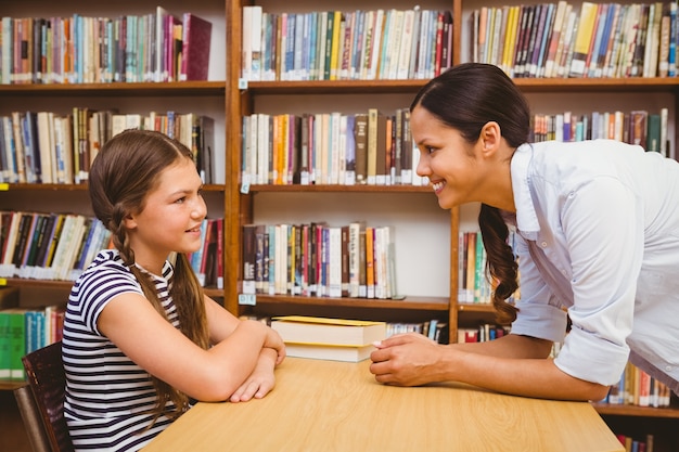 Vrouwelijke leraar en meisje in de bibliotheek