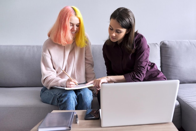 Vrouwelijke leraar leert individueel student, tiener en tutor die op kantoor op de bank werkt. Onderwijs, hulp, lesgeven, schoolconcept