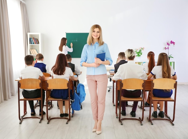 Vrouwelijke leraar met een notitieboekje in de klas