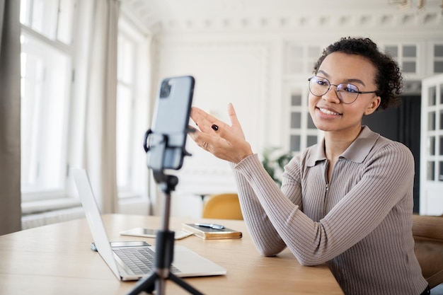 Vrouwelijke manager gebruikt telefoon op bureauchat online videogesprek in nieuw kantoor