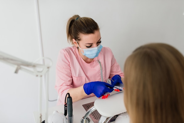 Vrouwelijke manicure meester in een schoonheidssalon werken met de handen van de klant