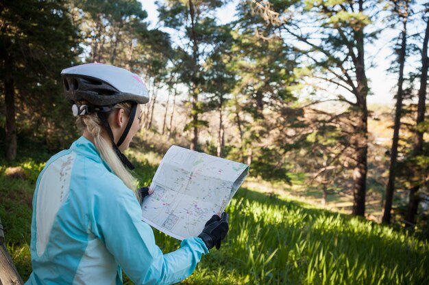 Foto vrouwelijke mountainbiker kaart kijken