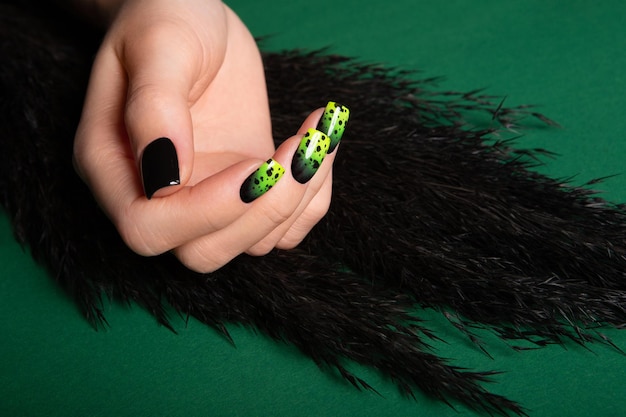 Vrouwelijke nette hand met korte natuurlijke nagels geverfd met groene nagellak