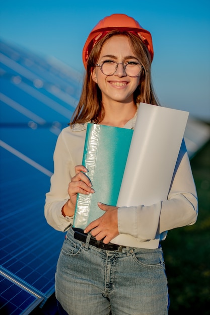 Vrouwelijke ondernemers bezig met het controleren van apparatuur op zonne-energiecentrale met tabletchecklist