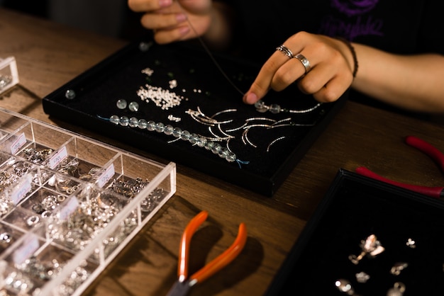 Vrouwelijke ontwerper die sieraden maakt in een juwelier