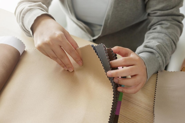 Vrouwelijke ontwerper met stofkleurstalen die textiel voor gordijnen kiest