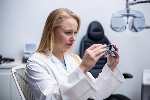 Vrouwelijke optometrist die door messbrille kijkt