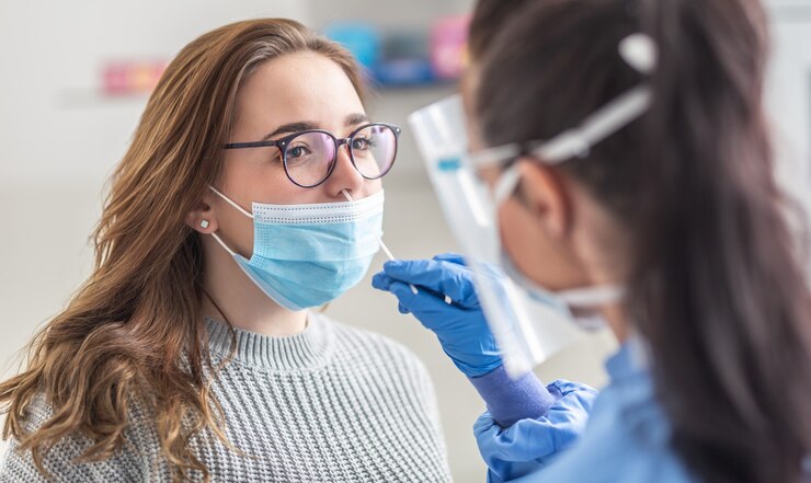 Foto vrouwelijke patiënt die een masker over de mond draagt, laat een monster uit de neus nemen voor een pcr-test voor covid 19.