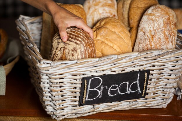 Vrouwelijke personeel houden brood aan balie in bakkerij