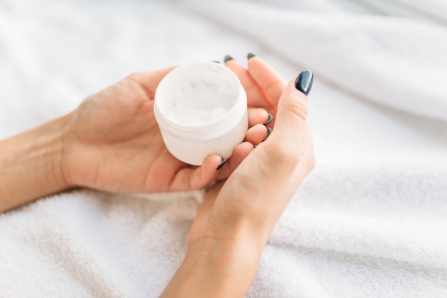 Vrouwelijke persoon handen met cosmetische crème close-up, huidverzorging. Lichaamsverzorging en hygiëne, gezondheidszorg