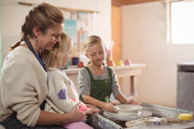 Foto vrouwelijke pottenbakker die meisjes bijstaan