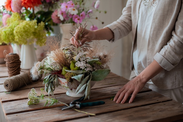 Vrouwelijke professionele bloemist bereidt de opstelling van wilde bloemen voor.