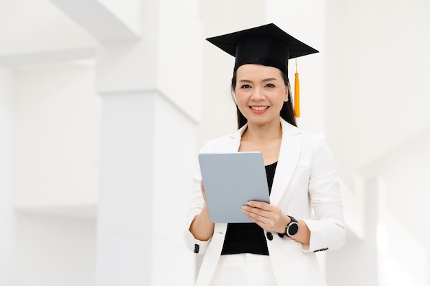 Vrouwelijke promovendi met gele kwastjes en zwarte afstudeerpetten zijn aan de universiteit.