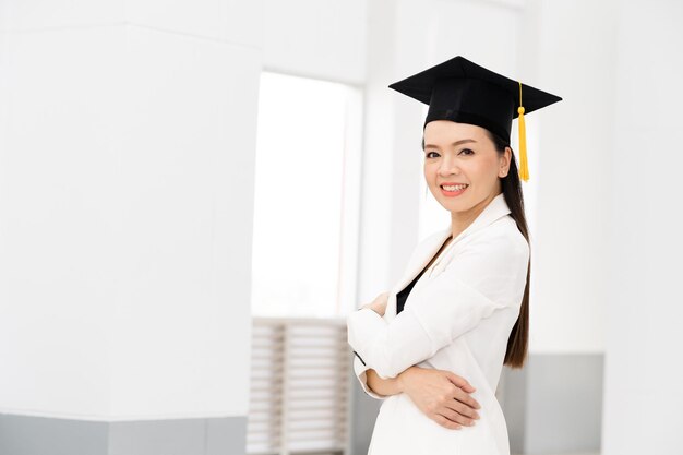 Vrouwelijke promovendi met gele kwastjes en zwarte afstudeerpetten zijn aan de universiteit.