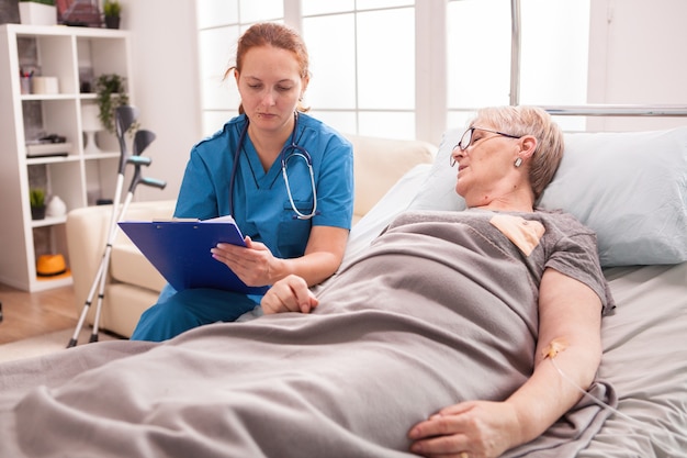 Vrouwelijke psycholoog in gesprek met senior vrouw in verpleeghuis.