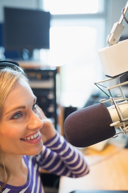 Vrouwelijke radiopresentator die in studio uitzendt
