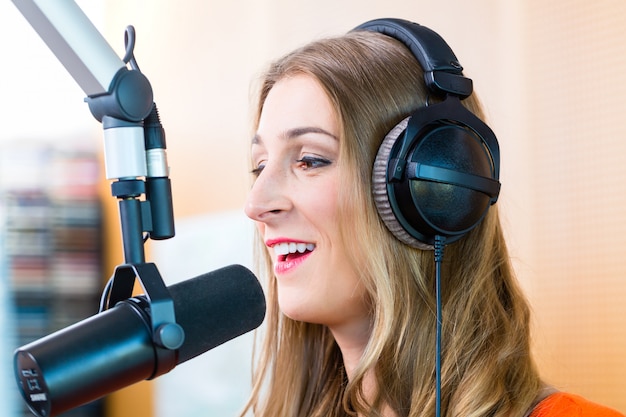 Vrouwelijke radiopresentator in radiostation op lucht