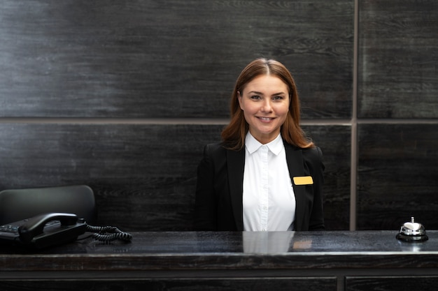 Foto vrouwelijke receptioniste in elegant pak tijdens werkuren