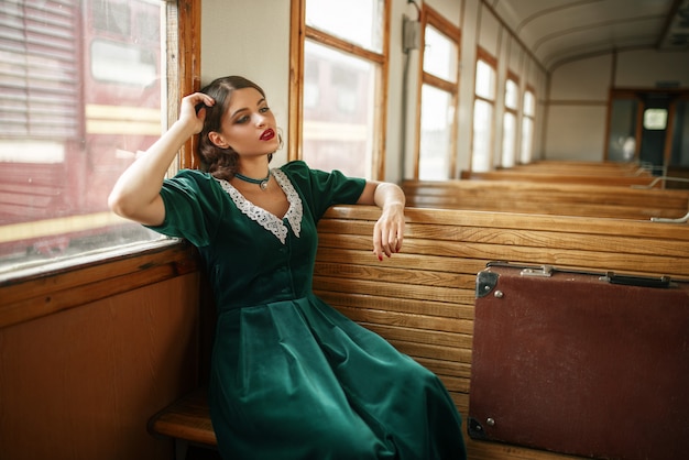 Vrouwelijke reiziger in retro trein, oud wagenbinnenland. Spoorwegreis. Vintage reis