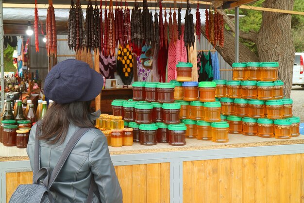 Vrouwelijke reiziger voor een souvenirstand met lokale producten uit georgië