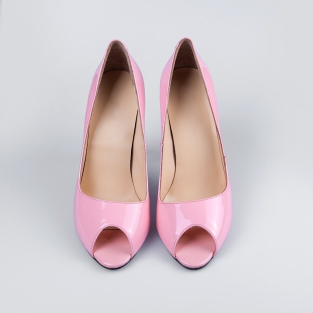 Vrouwelijke roze schoenen over wit