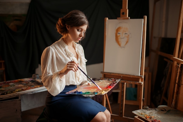 Vrouwelijke schilder houdt kleurenpalet en penseel