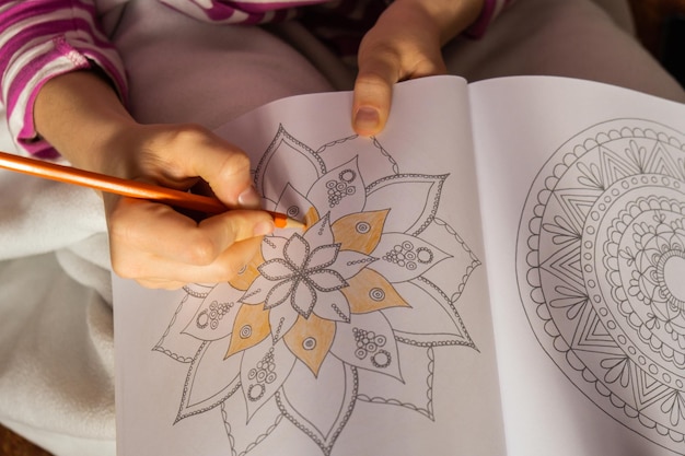 Foto vrouwelijke schilderen mandalas antistress pagina om stress te bestrijden ontspannende hobby mentaal welzijn en kunst