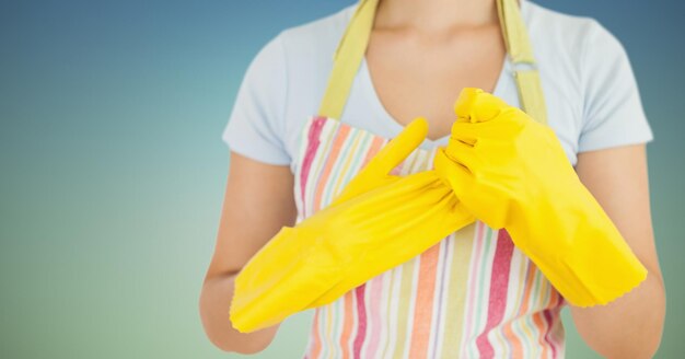 Vrouwelijke schoonmaakster met schort en rubberen handschoenen