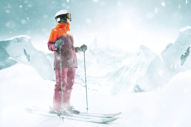 Foto vrouwelijke skiër permanent met luchten in de ene hand op de prachtige achtergrond van het berglandschap. winter, ski, sneeuw, vakantie, sport, vrije tijd, lifestyle concept