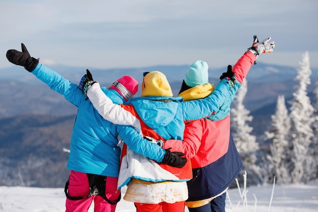 Vrouwelijke skiërs, snowboarders verheugen zich op de berghelling