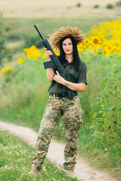 Vrouwelijke soldaat in militair uniform Een meisje in een militair uniform met een wapen Oekraïense vrouw in een krans