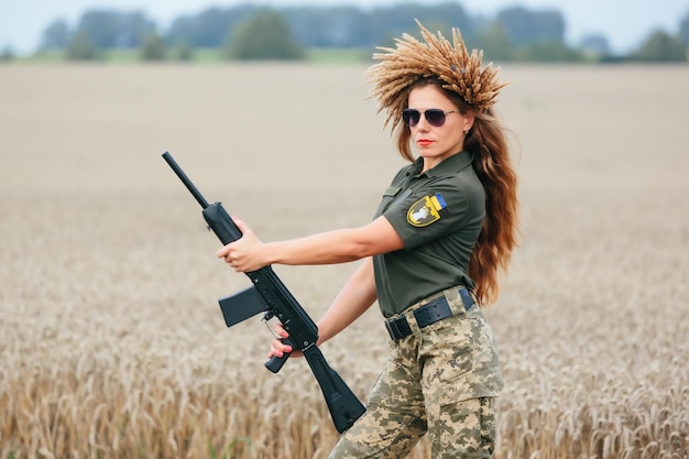 Vrouwelijke soldaat in militair uniform Een meisje in een militair uniform met een wapen Oekraïense vrouw in een krans