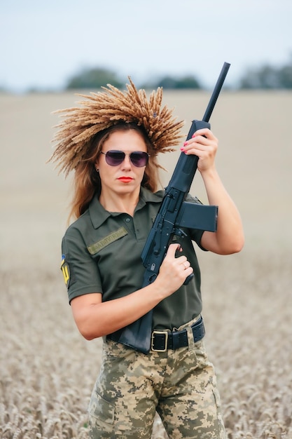 Vrouwelijke soldaat in militair uniform Een meisje in een militair uniform met een wapen Oekraïense vrouw in een krans