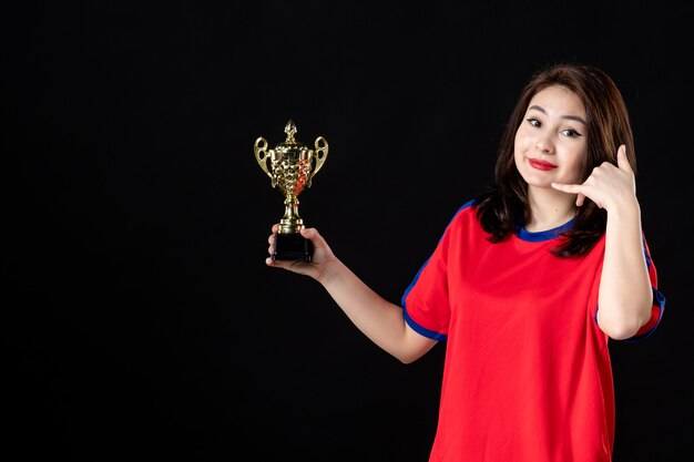 Vrouwelijke speler met gouden beker op zwart