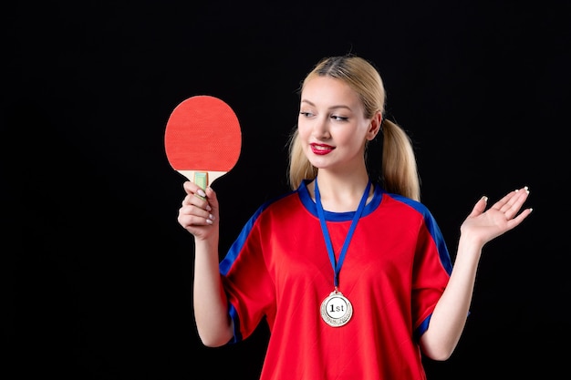 vrouwelijke speler met racket en gouden medaille op een winnaar van de trofee-atleet met zwarte achtergrond